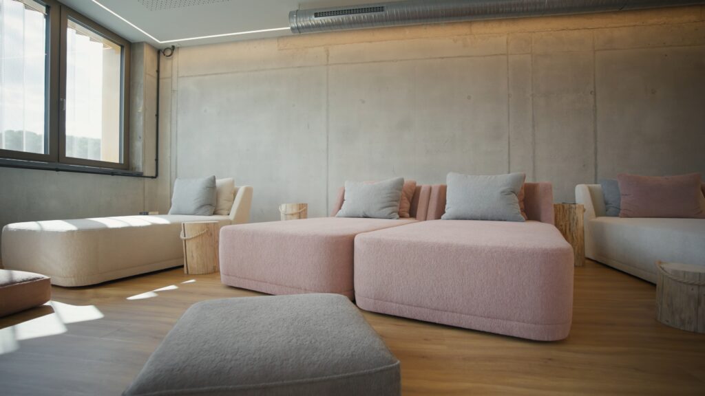 moderne-büro-lounge interior-aufnahme tageslicht-aufnahme betonwand-industrial-look gemütliche-sofas interview-setup imagefilm-dreh recruiting-video-location