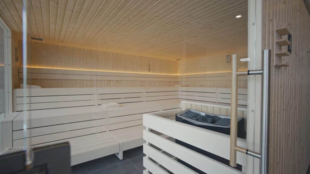 Interieur-Aufnahme, Wellness-Sauna, helle-Holzverkleidung, LED-Ambientelicht, Saunaofen-mit-Steinen, Architektur-Detail, Imagefilm-Dreh, Produktvideo-Dreh, Hotel-und-Spa-Location