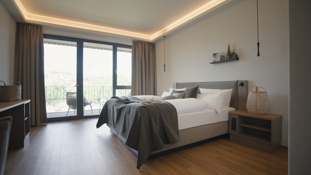 Imagefilm-Dreh Modernes-Hotelzimmer Interior-Aufnahme Weitwinkel-Perspektive Tageslicht-Stimmung Balkon-Blick Bodentiefe-Fenster Hochwertige-Materialien Minimalistisches-Design Hospitality-Content