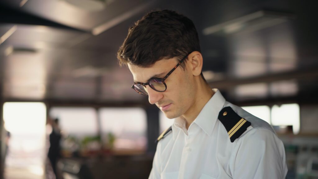 Recruiting-Video-Maritime, Imagefilm-Dreh-Schiffsbrücken-Setting, Maritime-Industrie-Umgebung, Uniformierter-Mitarbeiter-Close-up, Arbeitsalltag-Navigation, Natürliches-Licht-Look, B2B-Filmproduktion-Content