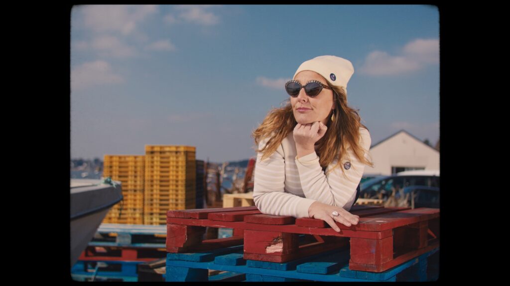 Imagefilm-Dreh Outdoor-Szene Hafen-Location Industrie-Setting Portrait-Aufnahme bunte-Paletten Kisten-Stapel natürliche-Lichtstimmung Cinematic-Look