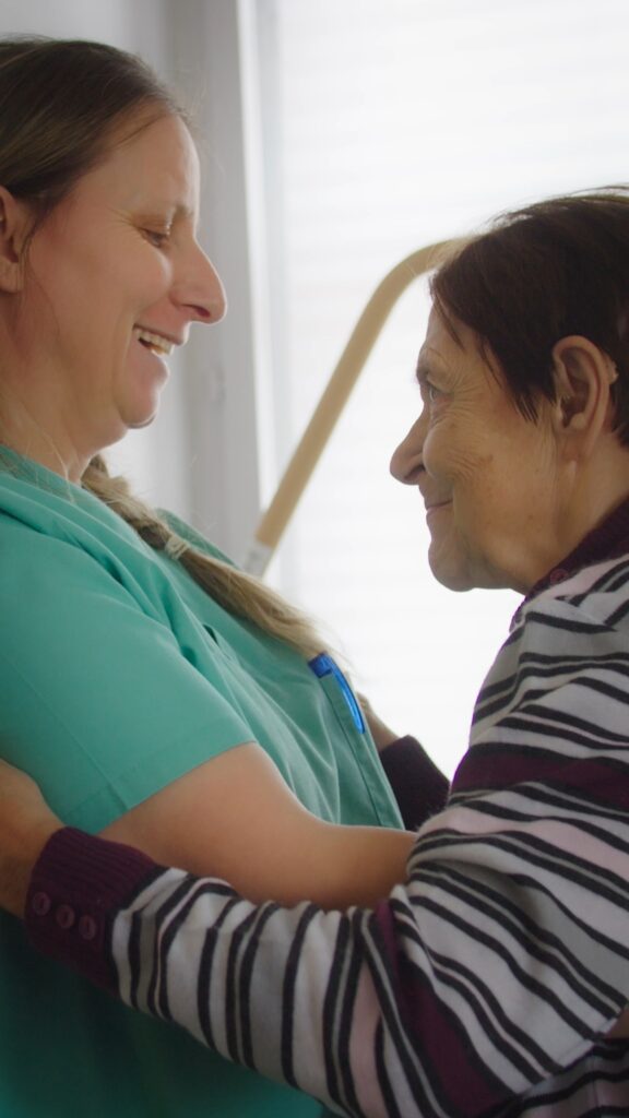 Recruiting-Video-Pflege, Imagefilm-Pflegedienst, Pflegekraft-mit-Seniorin, herzliche-Interaktion, Nahaufnahme-Setting, Innenraum-Available-Light, dokumentarischer-Look, Social-Media-Hochformat