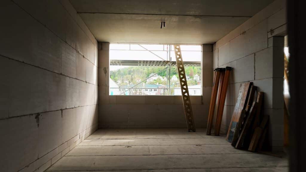 baustelle-rohbau-innenraum, industrie-umgebung, große-fensteröffnung-mit-gerüst, leiter-und-baumaterial, bau-dokumentation, imagefilm-dreh, recruiting-video-bau