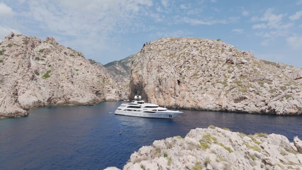 drohnenaufnahme-luxusyacht-felsbucht-azurblaues-meer-maritime-imagefilm-szene