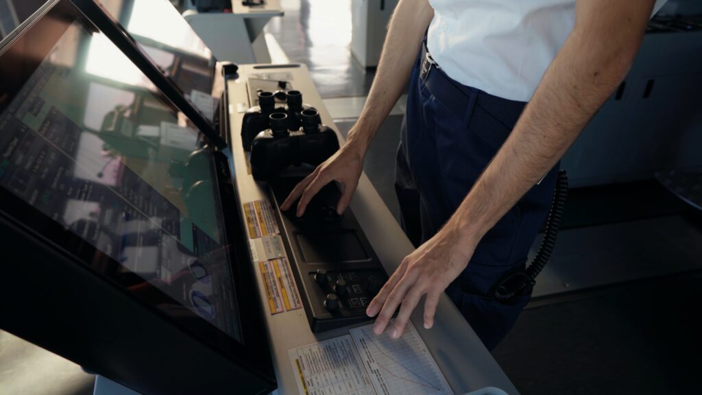 Industrieumgebung-Schiffsbrücken-Kontrollraum, Maritime-Technik, Navigation-Display, Bedienpult-Close-up, Hände-am-Steuerknopf, Sicherheitsausrüstung-Fernglas, Produktvideo-Maritim, Imagefilm-Dreh, Technik-Detailaufnahme