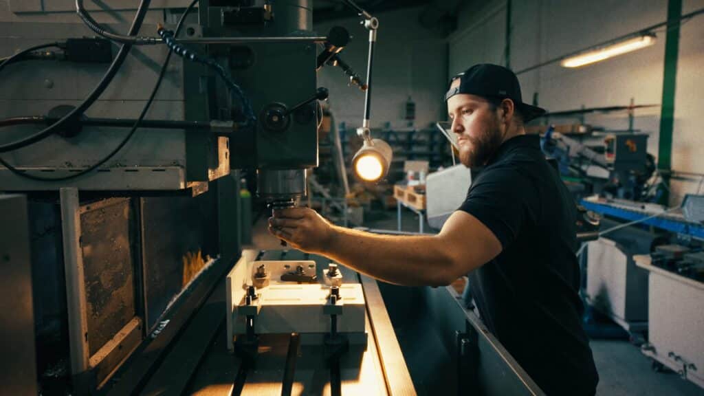 industrieumgebung-werkhalle, metallbearbeitung-cnc-fräse, maschinenbedienung-detail-shot, produktionsprozess-close-up, imagefilm-dreh-b2b, recruiting-video-handwerk, produktvideo-industrie, arbeitsplatz-arbeitslampe, präzision-fertigung