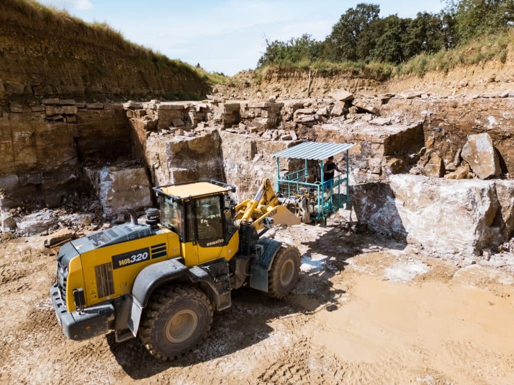 industrieumgebung-steinbruch-drohnenaufnahme-radlader-an-felswand-arbeitsablauf-sicherheitsplattform-imagefilm-dreh