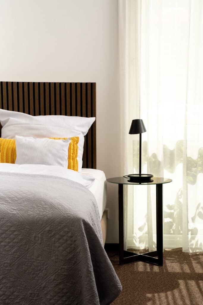 Interior-Setup, Hotelzimmer-Szene, Produktvideo-Möbel, Imagefilm-Hotellerie, Tageslicht-Dreh, Detailaufnahme-Nachttischlampe, Minimalistisches-Design, Weiches-Licht, Licht-Schatten-Spiel, Location-Scouting