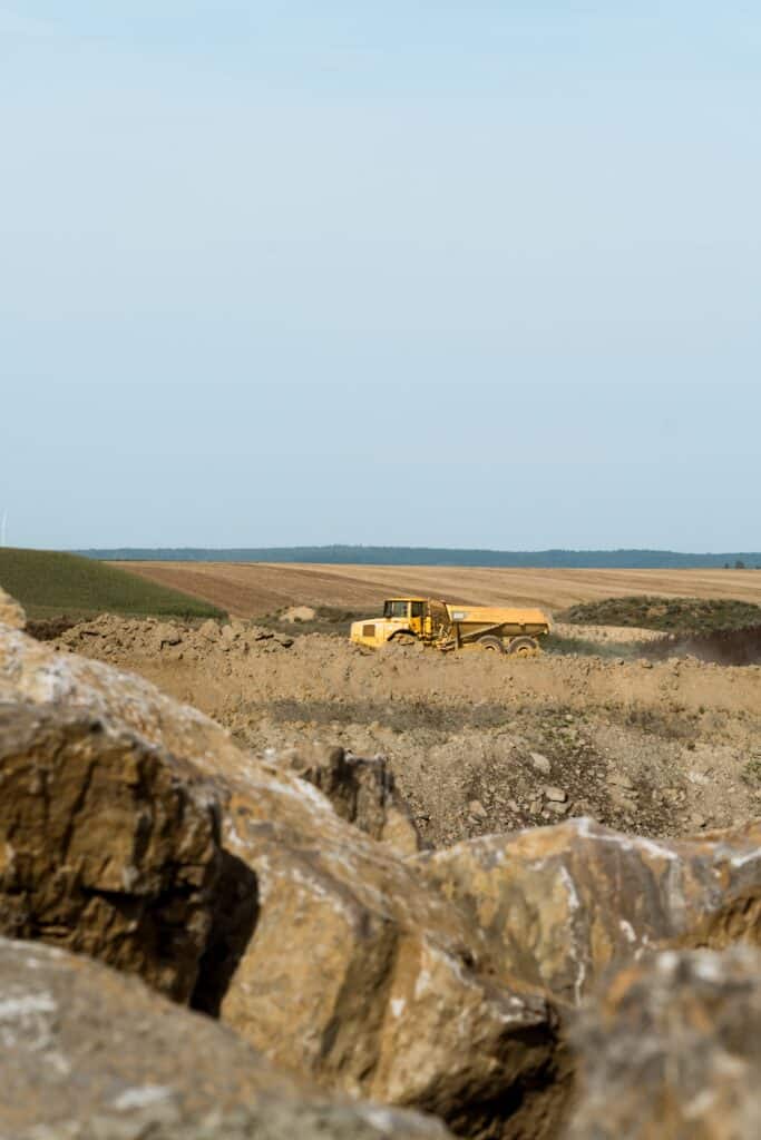 industrieumgebung-steinbruch, baustelle-erdbewegung, kipplaster-baumaschine, tagebau-landschaft, schwerlast-transport, produktvideo-industrie