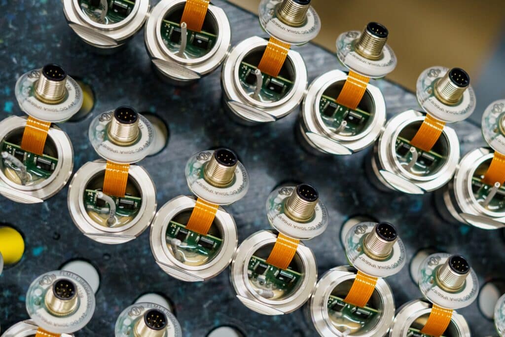 Industrie-umgebung, Elektronik-fertigung, Präzisions-sensoren, Steckverbinder-makro, Leiterplatten-detail, Serien-produktion, Fertigungs-prozess, Qualitäts-kontrolle, Makro-aufnahme, Produkt-video, Imagefilm-dreh, B2B-video
