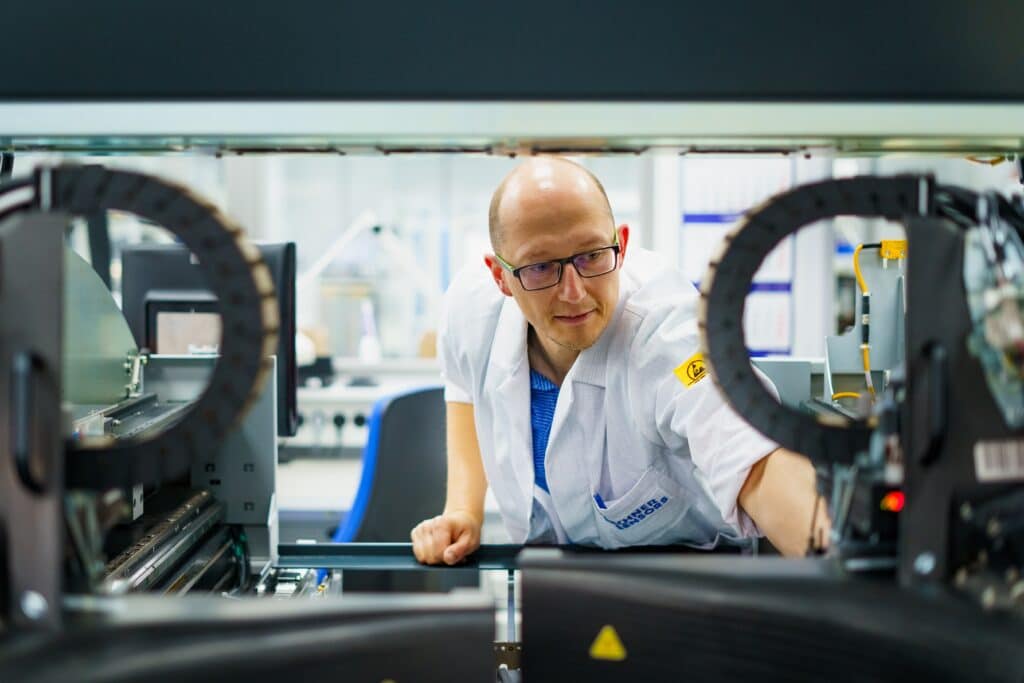 industrie-umgebung elektronik-fertigung mitarbeiter-bedient-produktionsmaschine präzisions-montage smt-bestückung produktions-linie nah-aufnahme imagefilm-dreh recruiting-video produkt-video b2b-videoproduktion
