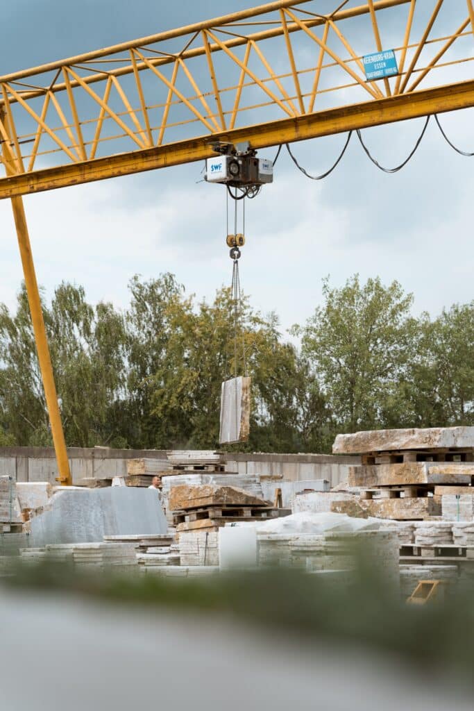 industrieumgebung-brückenkran-naturstein-logistik-schwerlast-werksgelände-kranaufnahme-produktionsfilm-b2b-video