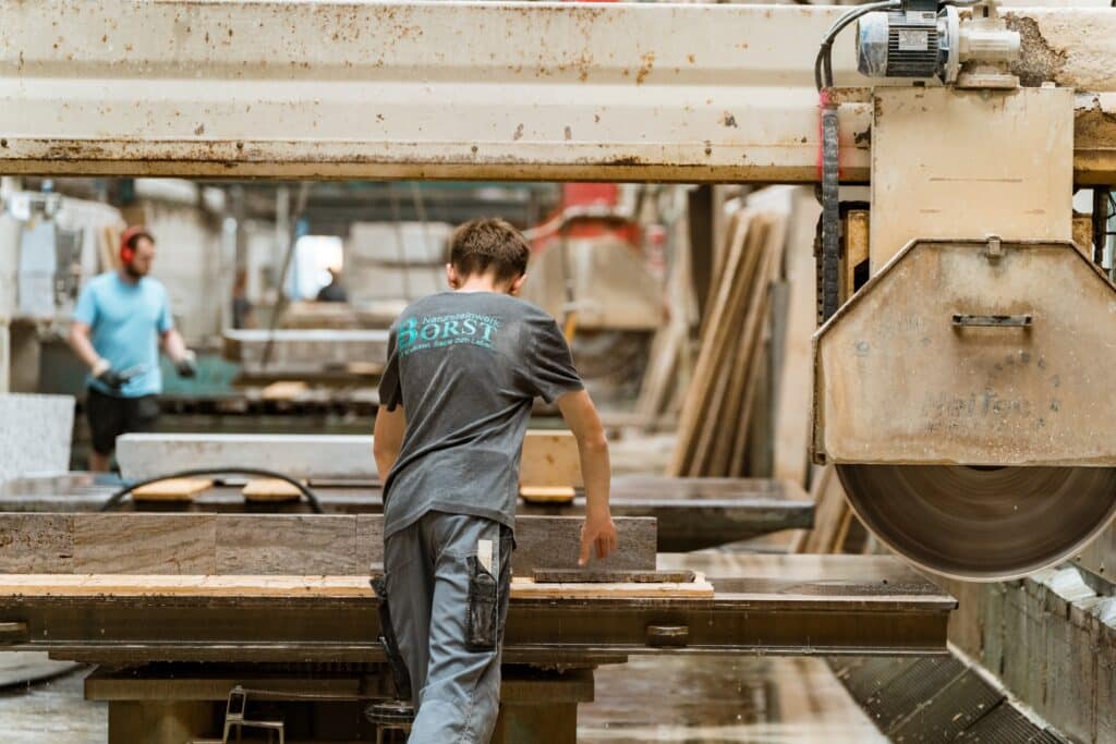 industrieumgebung-steinbearbeitung, produktionshalle-sägeanlage, steinplatten-zuschnitt, maschine-in-aktion, detailaufnahme-arbeitsprozess, imagefilm-dreh, recruiting-video-industrie, produktvideo-b2b, kamera-perspektive-werkhalle, sicherheit-am-arbeitsplatz, schnitt-postproduktion, farbbearbeitung-industrielook