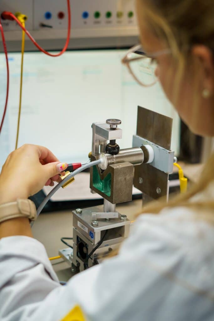 Produktvideo-Detailaufnahme, Sensor-Prüfstand, Labor-Setup, Technik-Nahaufnahme, Qualitäts-Kontrolle, Industrie-Umgebung, Forschung-und-Entwicklung, Kabel-Anschluss, Mess-Elektronik, High-Tech