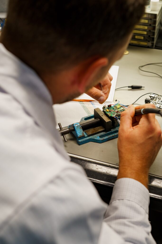 industrieumgebung-elektronikfertigung produktvideo-b-roll detailaufnahme-lötarbeit platine-smd-reparatur schraubstock-werkbank engineering-prozess nahaufnahme-technik imagefilm-industrie