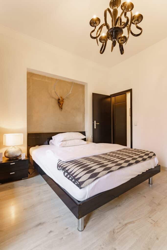 Interior-Aufnahme, Hotelzimmer-Location, Immobilien-Video, Architektur-Film, Imagefilm-Hotellerie, Setdesign-Detail, Bett-Setup, Deko-Geweih, Designer-Lüster, Weitwinkel-Shot, Warmes-Licht, Location-Scouting