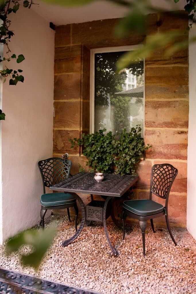Café-Terrasse Bistro-Setup Gusseisen-Möbel Steinwand-Ambiente Efeu-Deko Außenbereich-Location Mood-Aufnahme Imagefilm-Dreh Interview-Setup Location-Scouting Gastronomie-Werbefilm Detail-Aufnahme