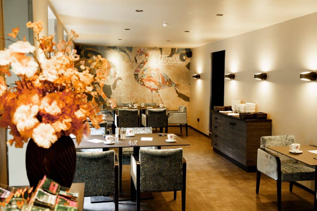 Imagefilm-Dreh, Gastronomie-Interior, Restaurant-Szene, Stilvolle-Deko, Wandkunst-Mural, Tisch-Setup, Available-Light, Cinematic-Look, Location-Scouting, B-Roll-Aufnahmen