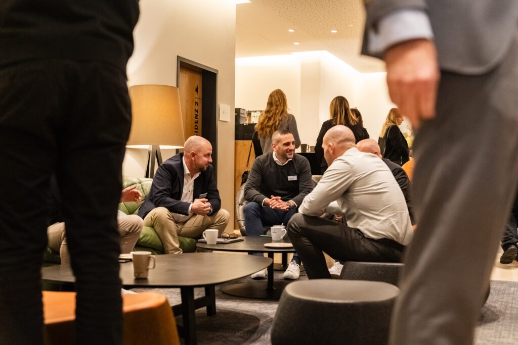 Business-Networking-Lounge, Unternehmens-Event, B2B-Eventfilm, Imagefilm-Motiv, Recruiting-Video-Content, Konferenz-Pausenszene, Kaffee-Gespräch, Corporate-Atmosphäre