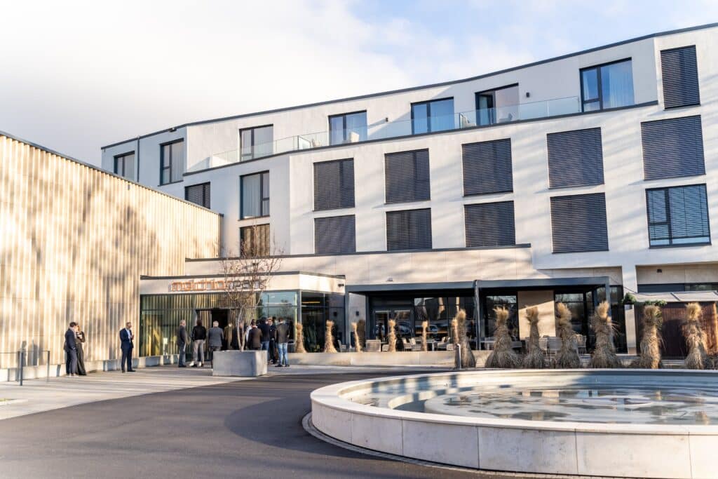 imagefilm-dreh, moderne-architektur, unternehmensstandort, außenaufnahme, eingangsbereich, business-event, networking, brunnen-vorplatz, tageslicht, corporate-ästhetik