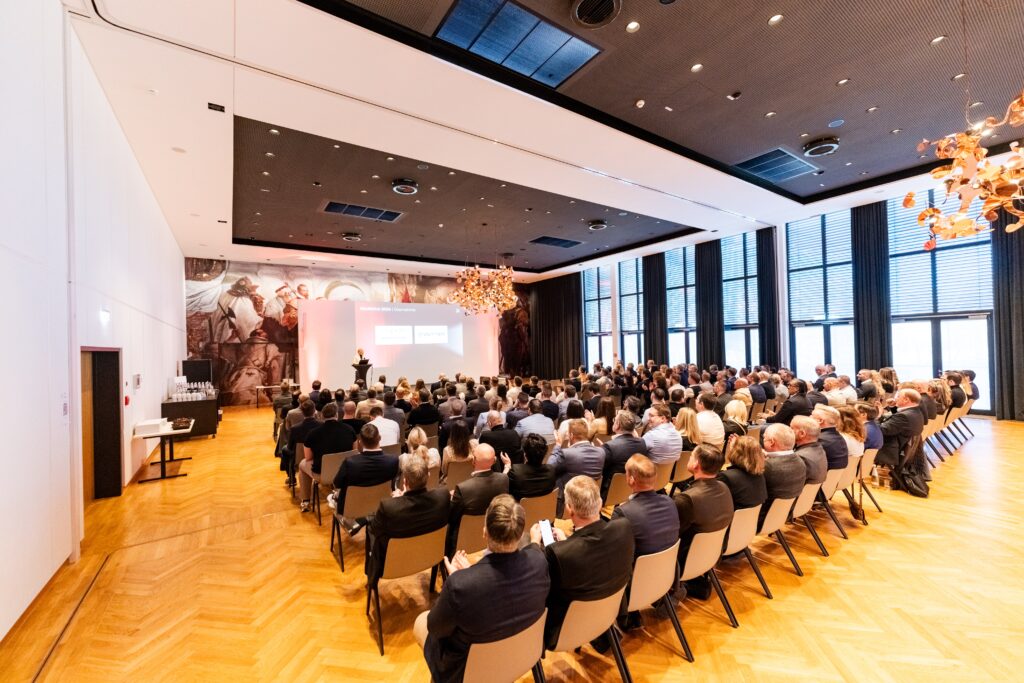 eventfilm-dreh business-konferenz keynote-bühne präsentations-setup konferenz-saal publikums-aufnahme live-event-dokumentation unternehmens-event bühnen-beleuchtung b2b-video konferenz-video