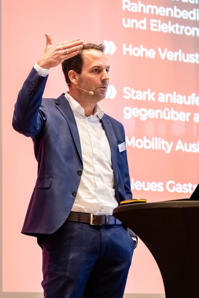 Konferenz-Video, Eventfilm-Produktion, Keynote-Aufnahme, Bühnenvortrag-mit-Headset, Präsentations-Bühne, Corporate-Event, Messe-Film, Business-Konferenz, Live-Recording, Redner-am-Pult