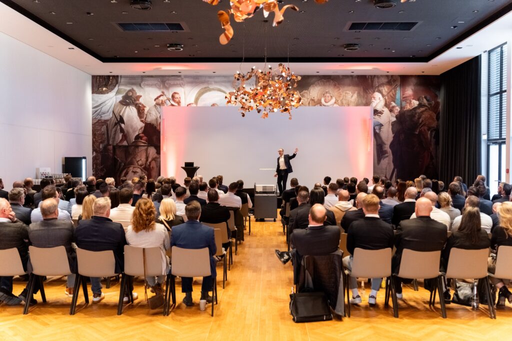 eventfilm-dreh, konferenz-film, keynote-aufzeichnung, bühnen-präsentation, großes-publikum, business-event, b2b-veranstaltung, live-vortrag, weitwinkel-aufnahme, bühne-und-leinwand