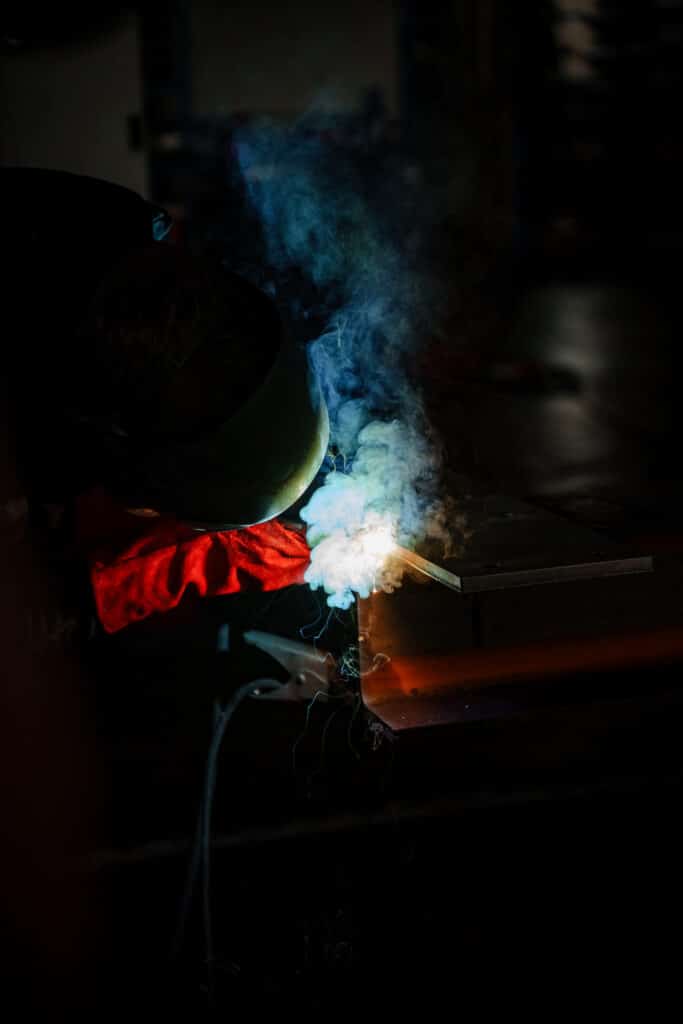 industrieumgebung-schweißarbeiten imagefilm-dreh b-roll-metallbau nahaufnahme-funken schweißrauch-lowlight werkstatt-szene produktvideo-industrie cinematic-lichtstimmung