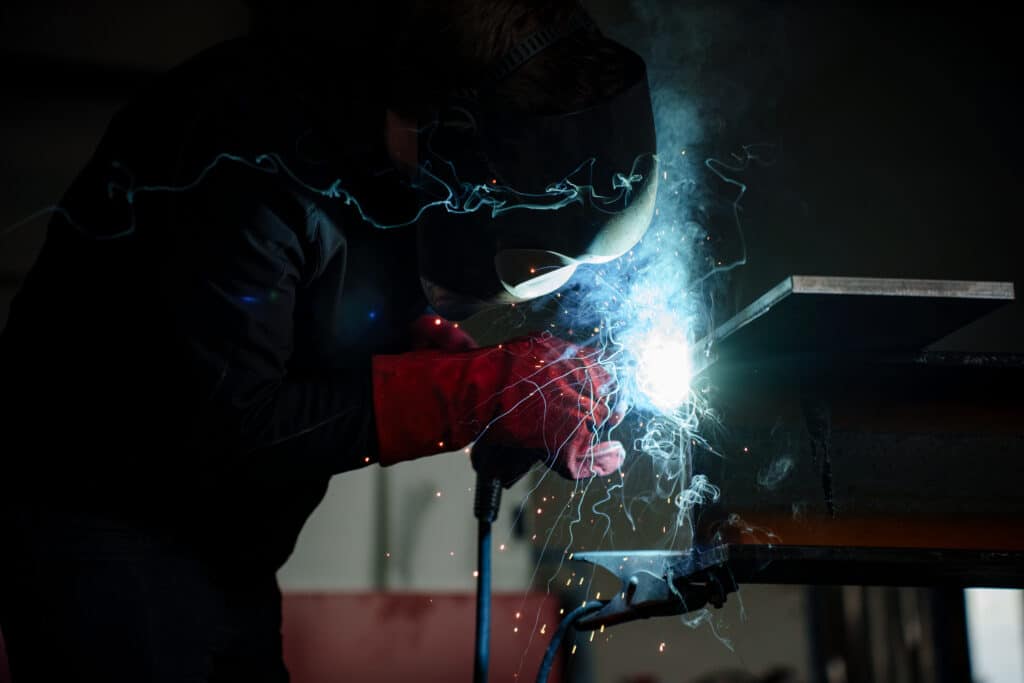industrieumgebung-schweißen funkenflug-nahaufnahme metallbau-produktion imagefilm-industrie recruiting-video-handwerk b2b-videoproduktion werkhalle-authentisch sicherheitsausrüstung-schweißmaske lowlight-ästhetik detailaufnahme-arbeitsprozess