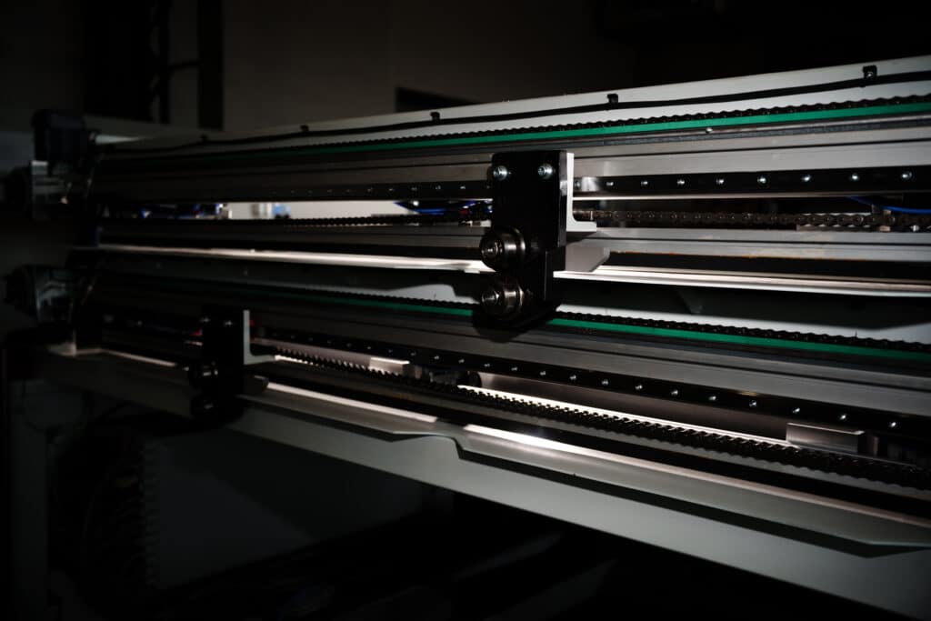 industrie-umgebung maschinen-detail ketten-antrieb linear-führung produkt-video makro-aufnahme präzisions-mechanik werk-halle low-key-licht knusper-studios