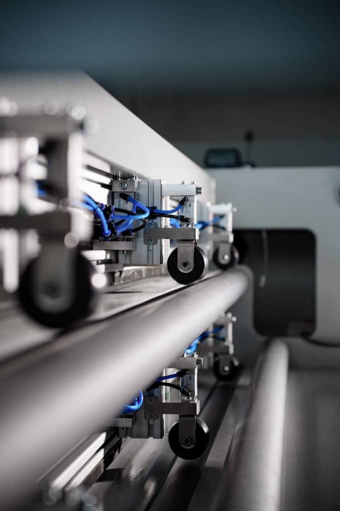 Industrie-Umgebung, Maschinen-Detailaufnahme, Produktionslinie-Nahaufnahme, Rollenförderer-Technik, Pneumatik-Leitungen, Metall-Komponenten, Hightech-Fertigung, Produktvideo-Industrie, Imagefilm-Fertigung, Makro-Kamera-Detail