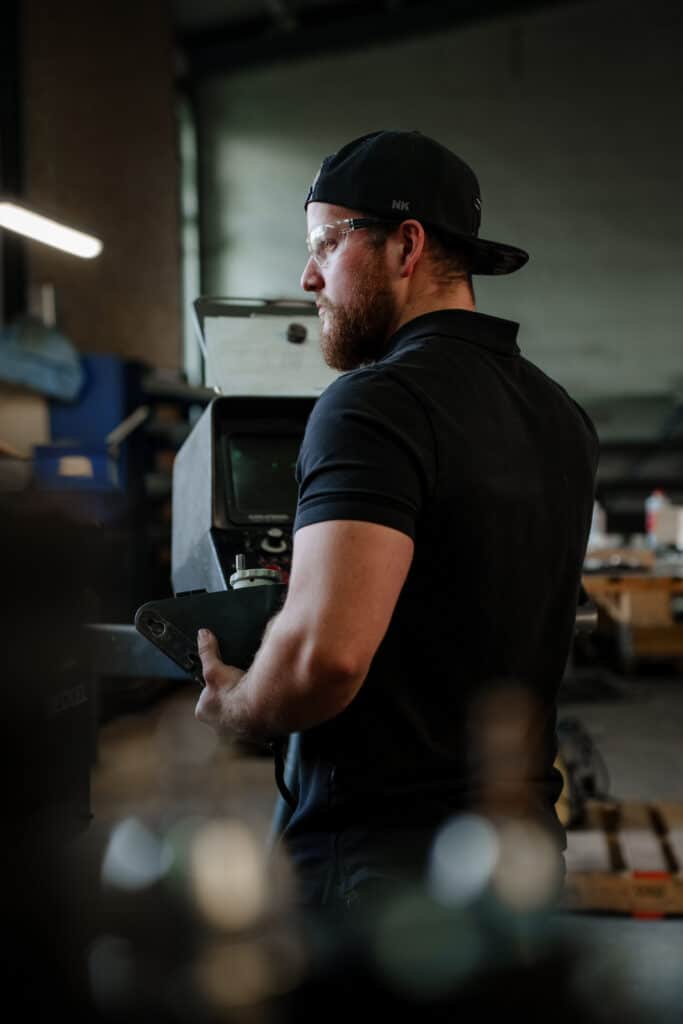 Industrieumgebung-Werkstatt, Maschinenbedienung-CNC, Mitarbeiter-mit-Schutzbrille, Produktionshalle-Detailaufnahme, Recruiting-Video-Imagefilm-Dreh
