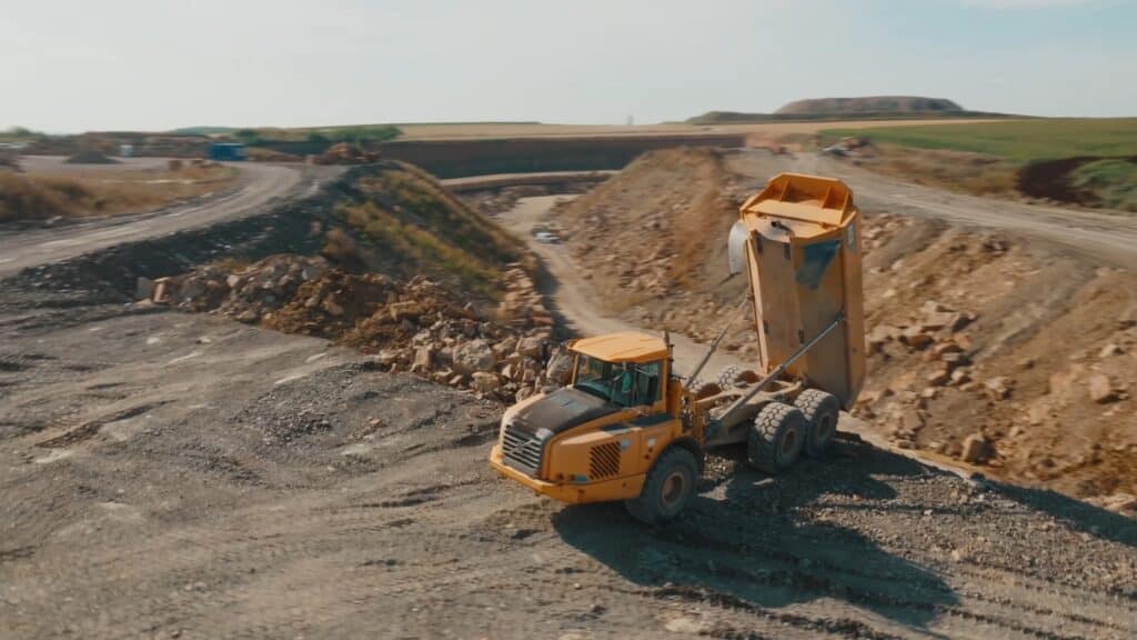 Industrieumgebung-Steinbruch Drohnenaufnahme-Kipper-Lkw Schwerlasttechnik-Erdbewegung Schüttgut-Entladung Baustellen-Imagefilm B2B-Industriefilm