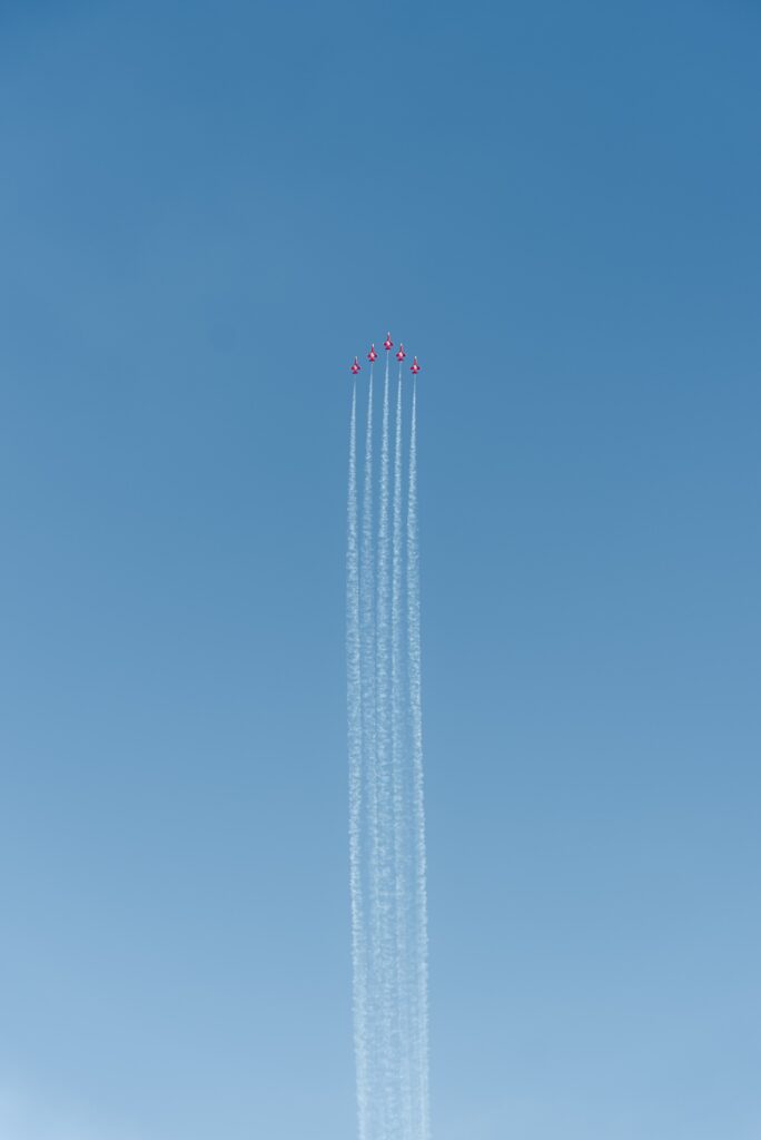Flugshow-Formation-Kunstflugjets-Kondensstreifen-Blauer-Himmel-Eventfilm-Actionshot-Luftaufnahme-Imagefilm-Cinematic