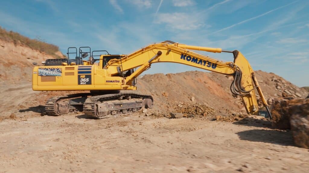 industrieumgebung-steinbruch, bagger-erdarbeiten, baustelle-schwerlast, kettenbagger-hybrid, geländeaufbereitung-abbau, produktvideo-b2b, imagefilm-bauindustrie