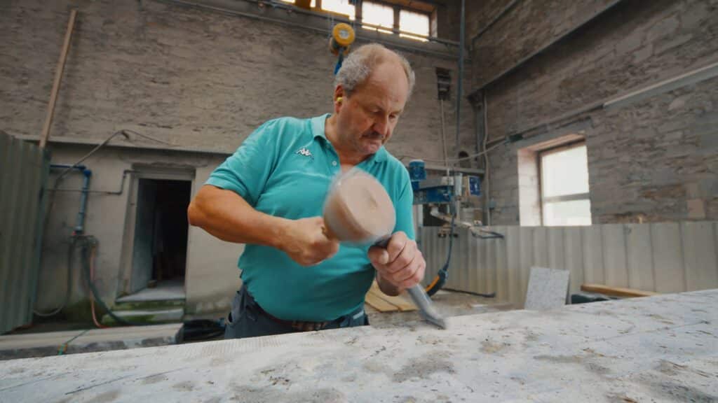 industrieumgebung-handwerk-steinbearbeitung-werkstatt-szene-meißel-und-schlegel-imagefilm-dreh-b-roll-produktionshalle-recruiting-video-facharbeiter-nahaufnahme