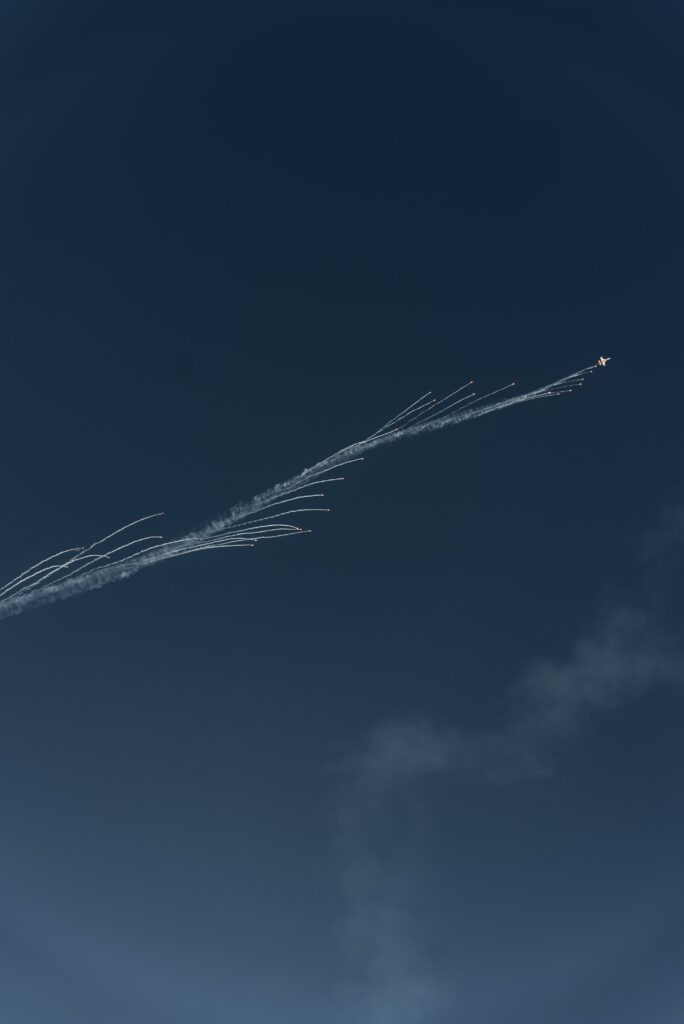 Luftaufnahme-Action Kunstflug-Jet Flares-Rauchspuren Highspeed-Flug Blauer-Himmel Airshow-Sequenz Teleobjektiv-Shot Cinematic-Look Imagefilm-Cutaway Event-Dokumentation Industrie-Luftfahrt