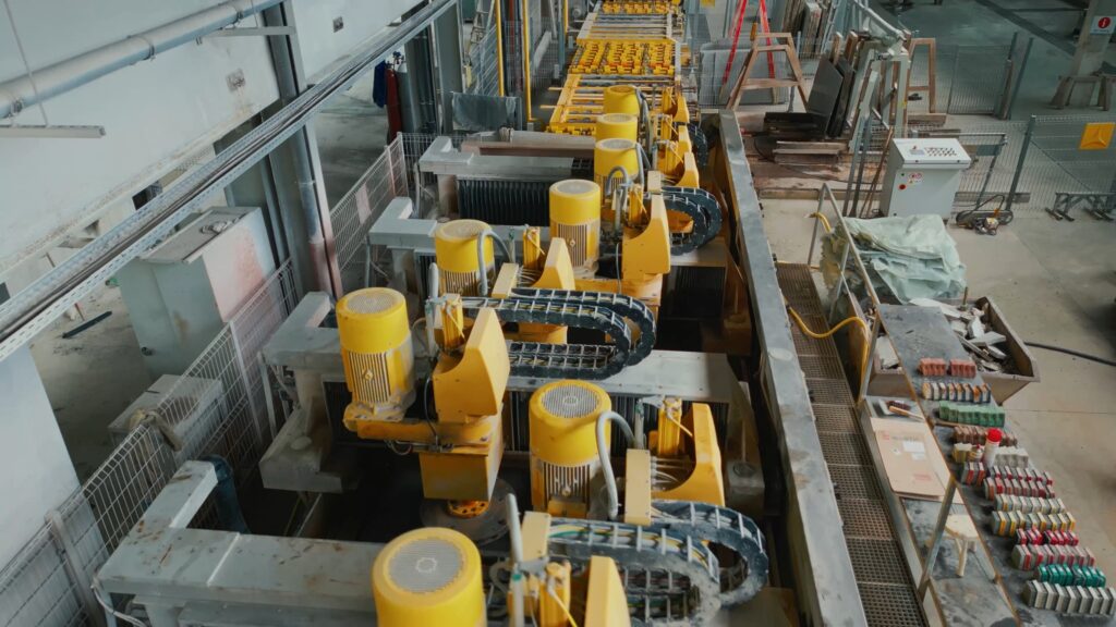 Industrie-Umgebung automatisierte-Produktionslinie Stein-Bearbeitung gelbe-Industriemaschinen Förderband-Anlage Werkhallen-Setting Draufsicht-Aufnahme Produktvideo-B2B