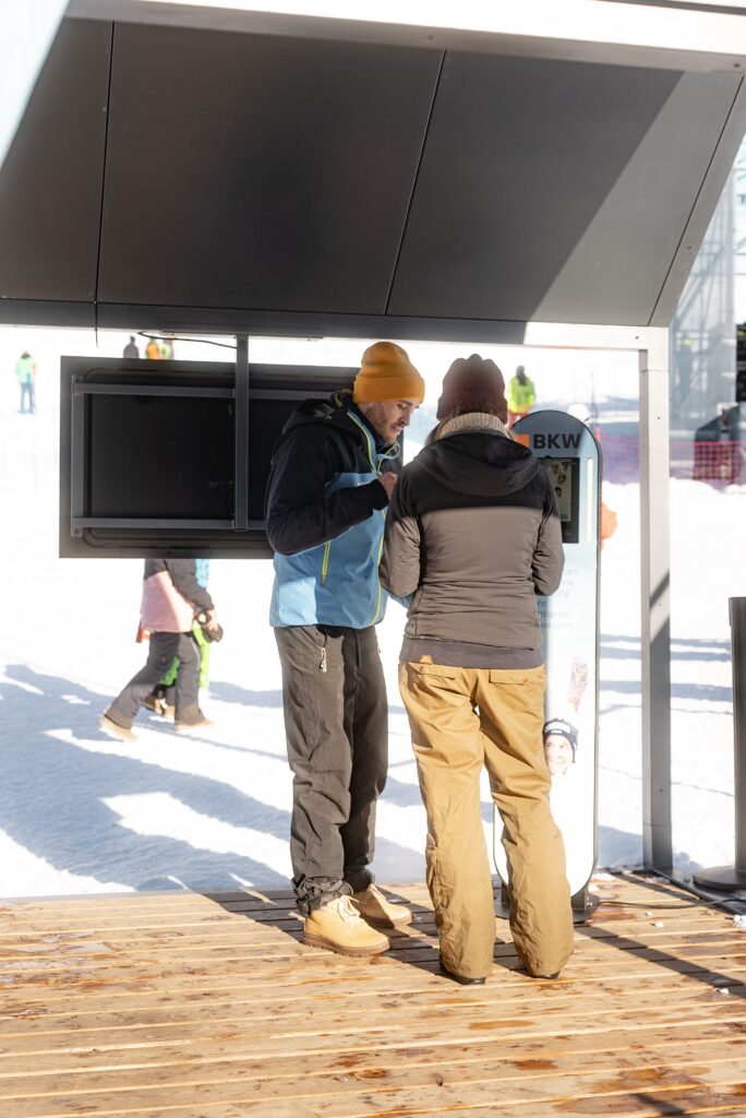Outdoor-Dreh-im-Skigebiet, Imagefilm-Setup, Wintersport-Location, Gespräch-am-Info-Terminal, Markenpräsenz, On-Location-Produktion, Available-Light, Authentische-Szenen