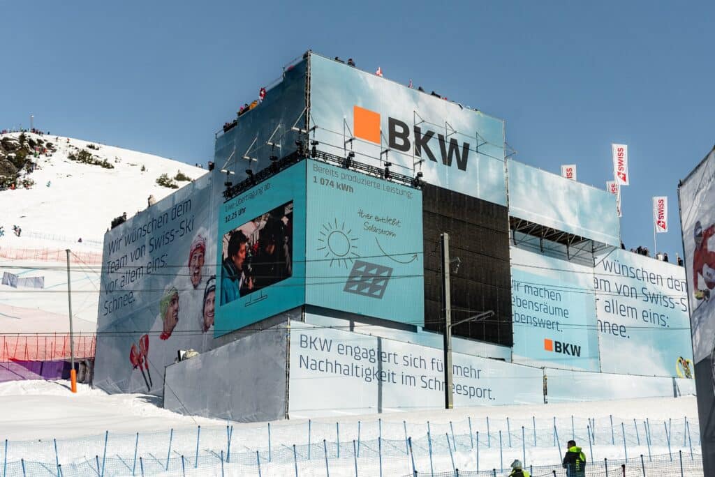 Ski-Event-Liveproduktion, Live-Übertragung, LED-Großbildschirm, Outdoor-Eventproduktion, Kamera-Setup, Marken-Branding, Gerüst-Bühnenbau, Schnee-Landschaft, Sponsor-Werbeflächen, Eventfilm-Produktion