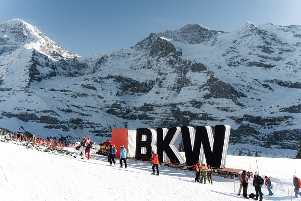 winterlandschaft-bergkulisse, skigebiet-eventproduktion, imagefilm-dreh-outdoor, bkw-branding-installation, großbuchstaben-bühne, drohnenaufnahme-geeignet, markeninszenierung-sportsponsoring