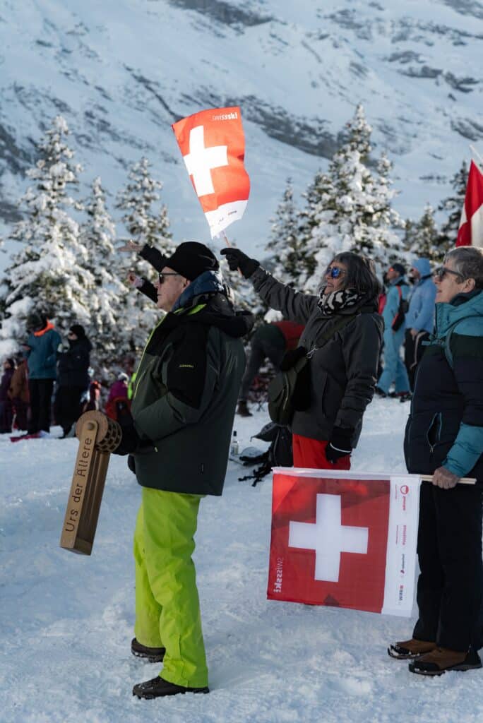 Eventfilm-Winter, Outdoor-Dreh, Skisport-Event, Bergkulisse-Schweiz, Zuschauer-mit-Schweiz-Flaggen, Schnee-Landschaft, Jubel-Stimmung, Reportage-Stil, Social-Media-Clip