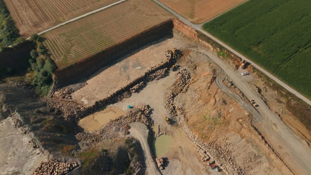 Drohnenaufnahme-Steinbruch Industrieumgebung-Baustelle Erdbewegung-Luftbild Bagger-Kipplaster Rohstoff-Abbau Industriefilm-Produktion