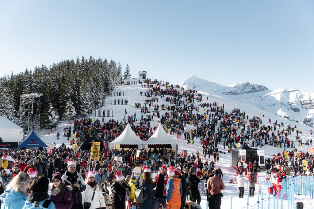 Wintersport-Event, Skigebiet-Alpenkulisse, Großes-Publikum, Festival-Zelte, Bühnen-Technik, Sponsor-Branding, Schneelandschaft-Weitwinkel, Eventfilm-Produktion, Live-Atmosphäre