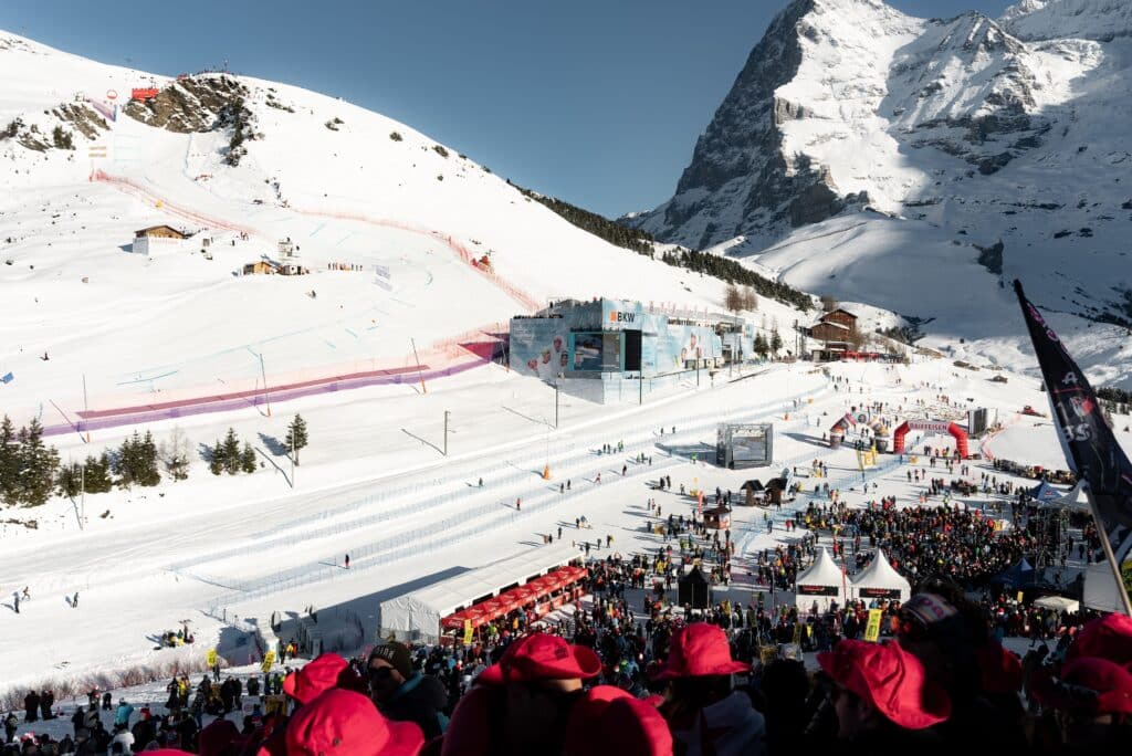 Eventfilm-Wintersport, Ski-Rennen, Winter-Landschaft, Berg-Panorama, Ziel-Bereich, Publikums-Menge, Sponsor-Branding, Großbildschirm-Livefeed, Outdoor-Produktion, Kamera-Setup, Drohnen-Aufnahme