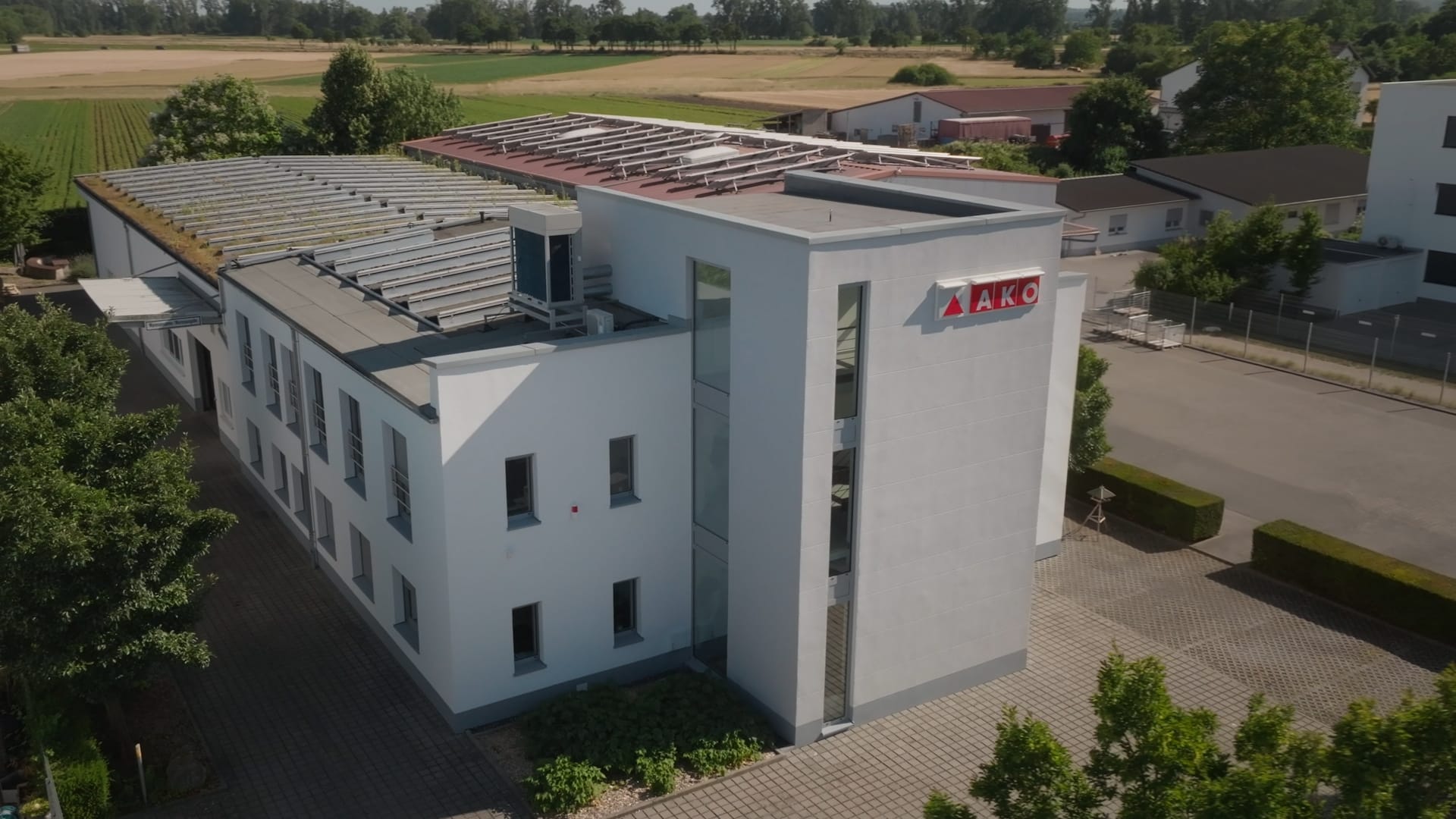 drohnenaufnahme-industrieumgebung-firmengebäude-luftbild-unternehmensstandort-moderne-architektur-dachkonstruktion