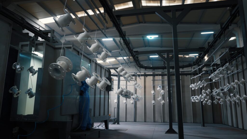 Industrieumgebung-Pulverbeschichtung-Lackierkabine-Hängeförderanlage-Metallkomponenten-Fertigung-Produktionslinie-Prozessaufnahme-Produktvideo-B2B-Industriefilm-Imagefilm-Dreh