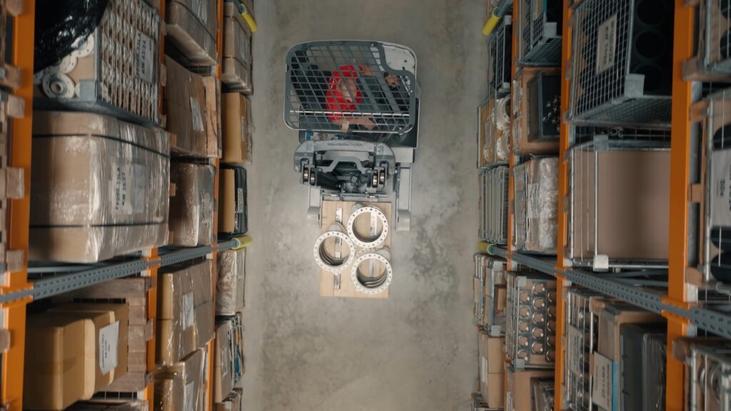 drohnenaufnahme-lagerhalle, industrieumgebung-logistik, gabelstapler-oberansicht, regalgang-lagerlogistik, metall-flansche-palette, imagefilm-dreh-industrie, produktvideo-b2b, knusper-studios