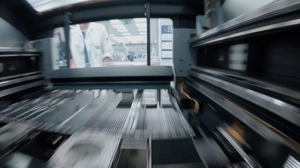 industrieumgebung-aufnahme produktvideo-dreh automatisierte-fertigung maschinen-innenperspektive kamerafahrt-durch-maschine förderstrecken-detail hightech-werkhalle robotik-im-hintergrund