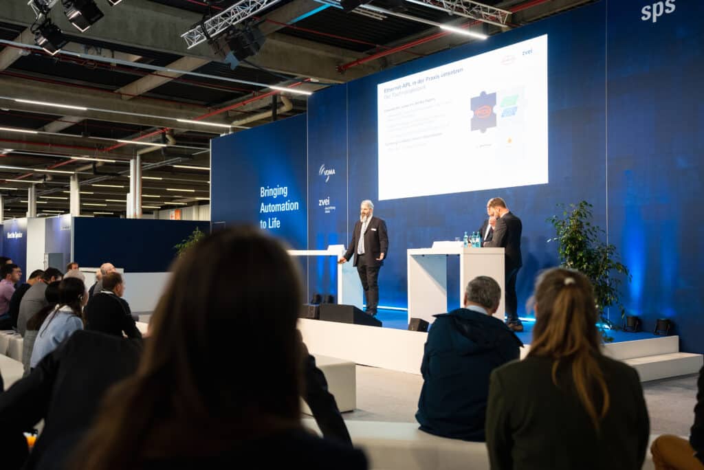 messefilm-dreh b2b-event industrie-automation bühnen-vortrag live-präsentation publikum-aufnahme keynote-aufzeichnung konferenz-halle branding-bühne